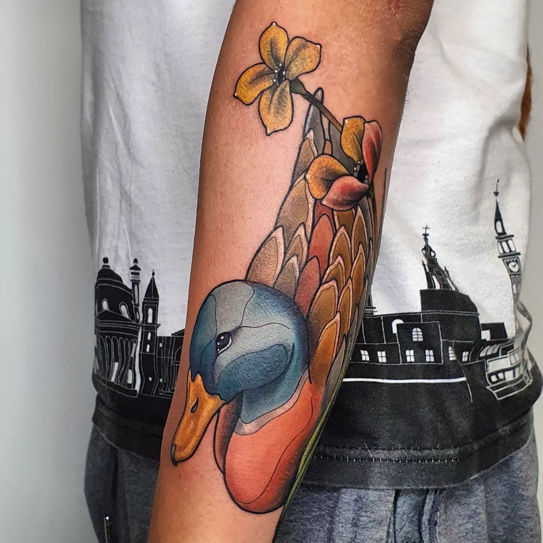 Colorful duck tattoo with flowers on arm