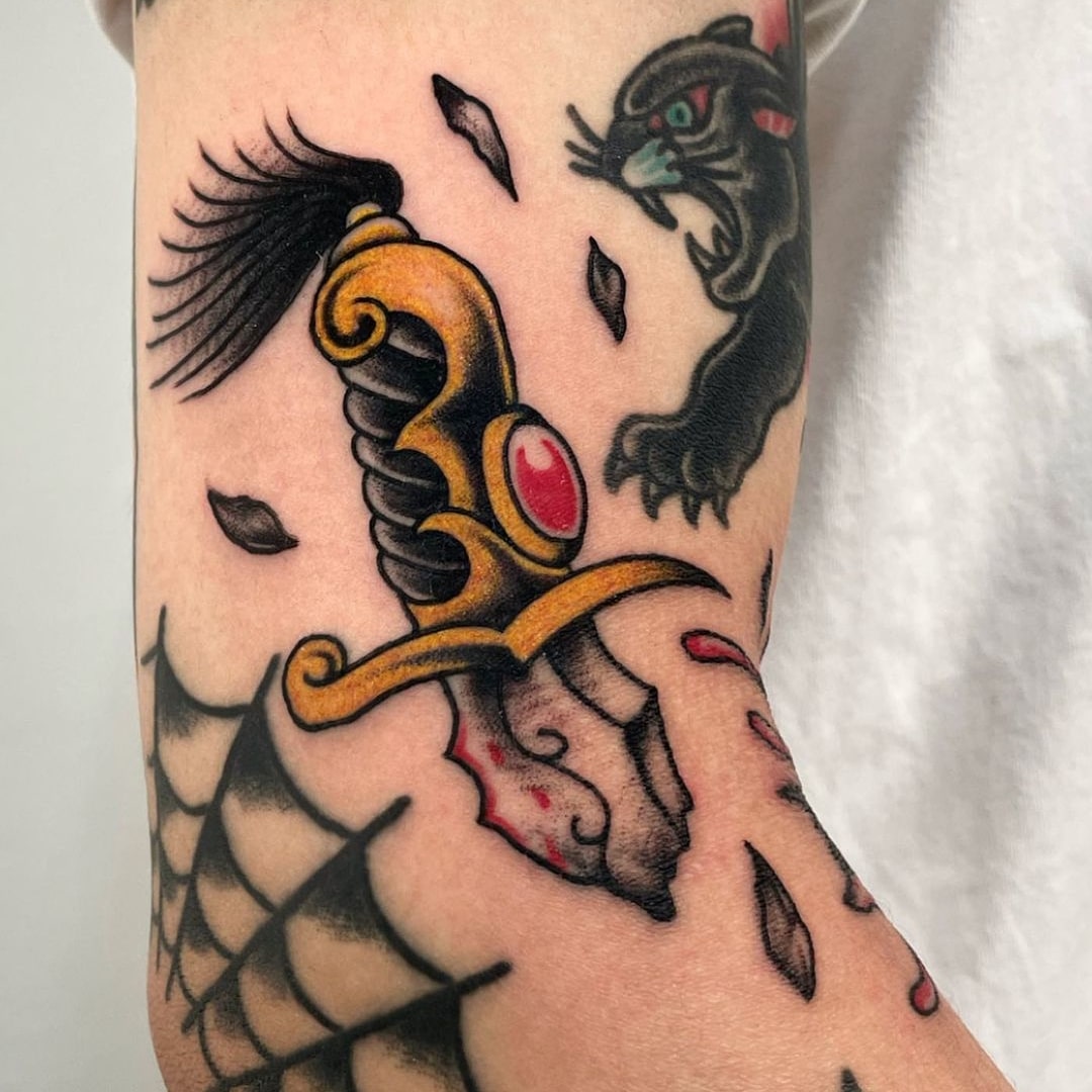 Colorful dagger and panther tattoo on skin