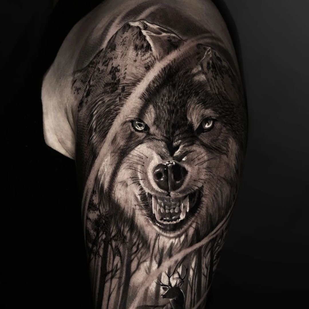 Detailed wolf tattoo on upper arm with mountain background