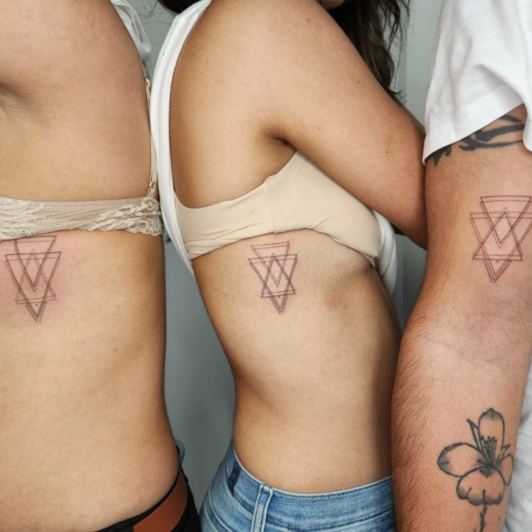 Three individuals showcasing their geometric tattoos on the side, featuring intricate designs.