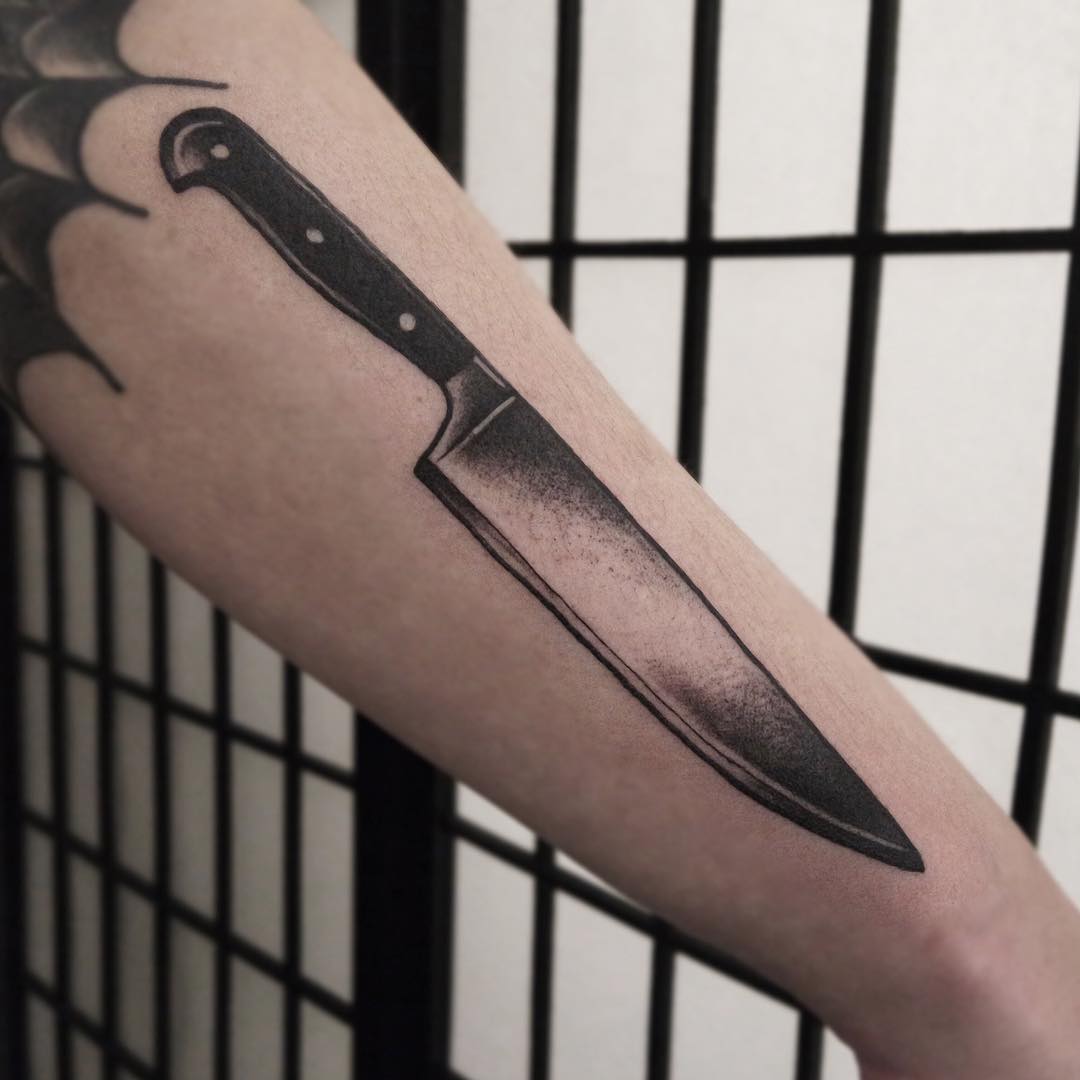 Realistic tattoo of a kitchen knife on an arm