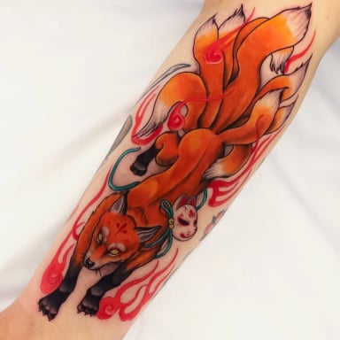 Intricate tattoo of a fox with nine tails and a mask