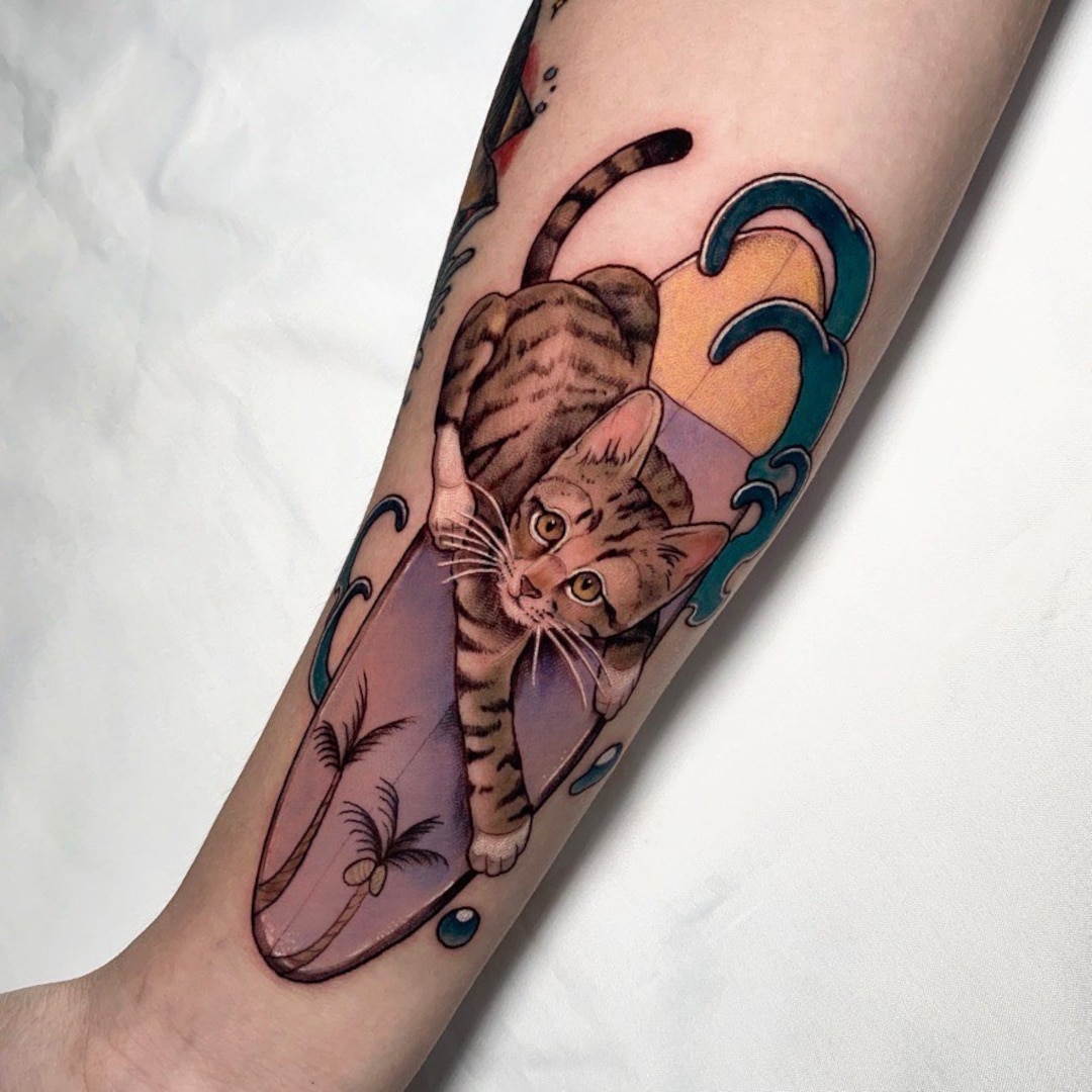 A detailed tattoo of a cat on a forearm.
