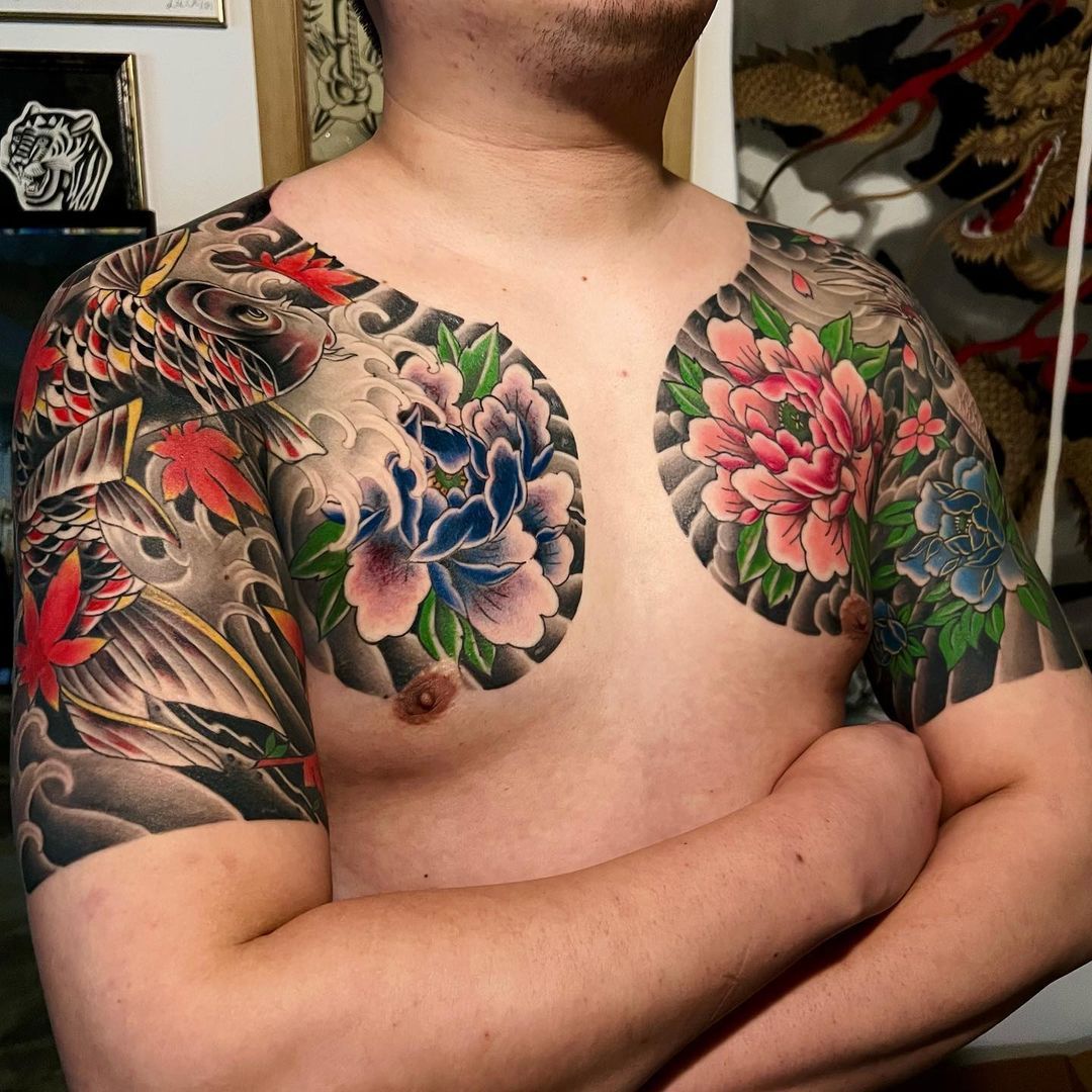 Man with intricate tattooed sleeves showcasing flowers and motifs.
