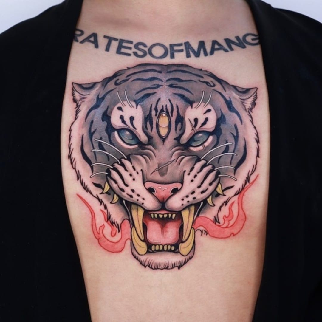 Tattoo of a fierce tiger head on a person's chest