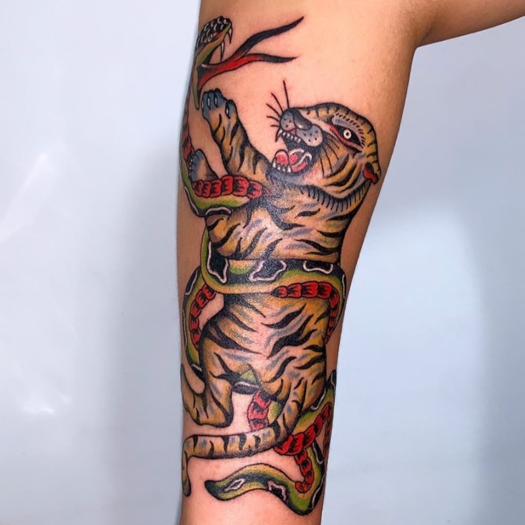 Tattoo of a tiger and a snake on a forearm